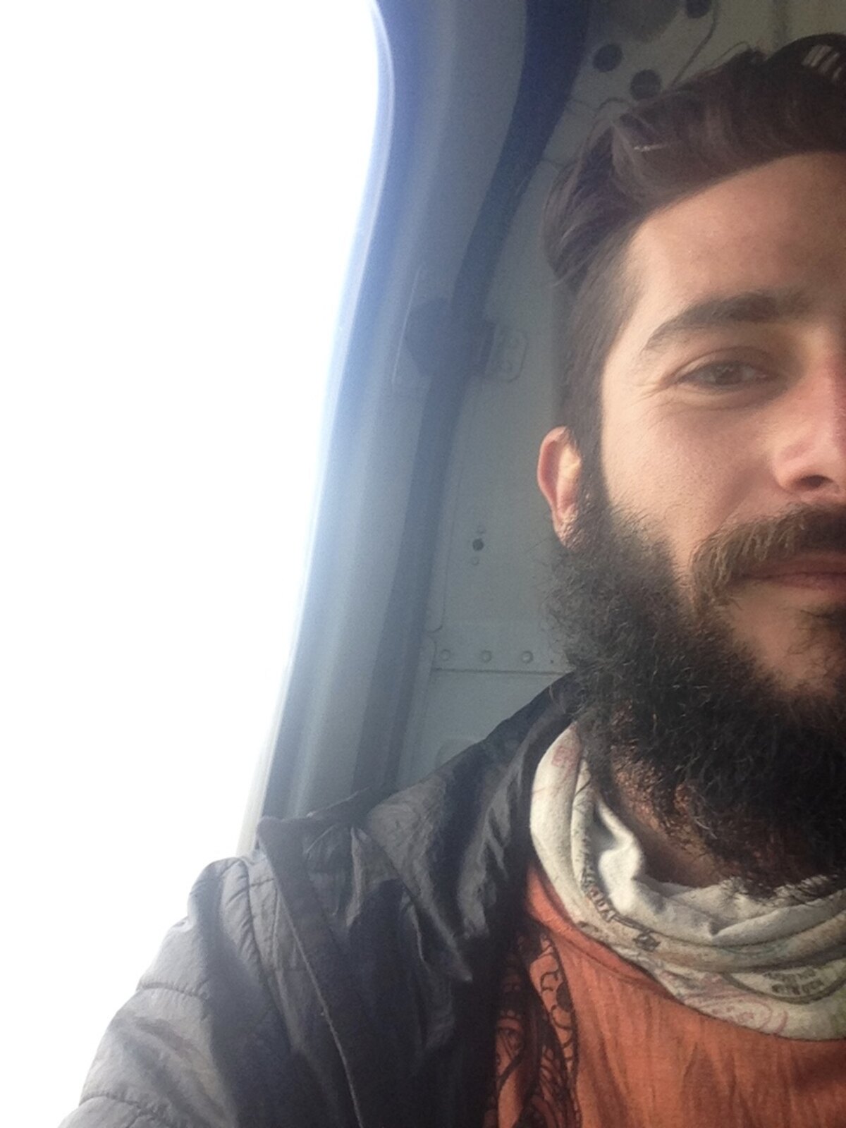 Peter inside the helicopter out of Nepal, beard grown long, weathered from a year on the road.